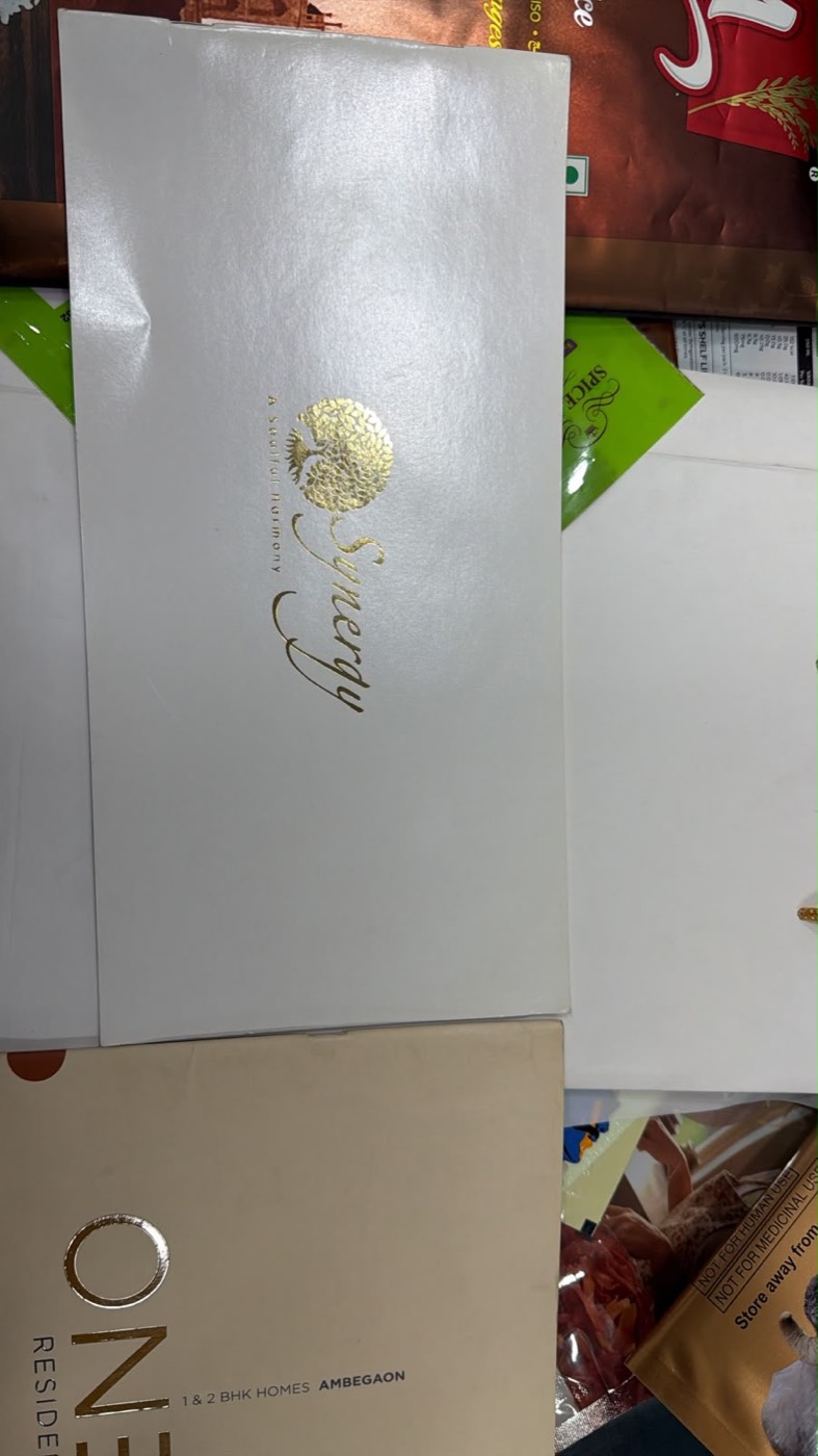 White envelope with gold foil-stamped monogram.